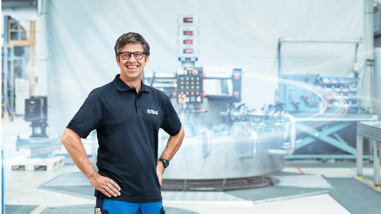 Mann steht in der Fabrik vor Pumpenmaschine. Mitarbeiter der Biral AG in Münsingen in der Produktion. Imagebild mit blauen Akzenten.