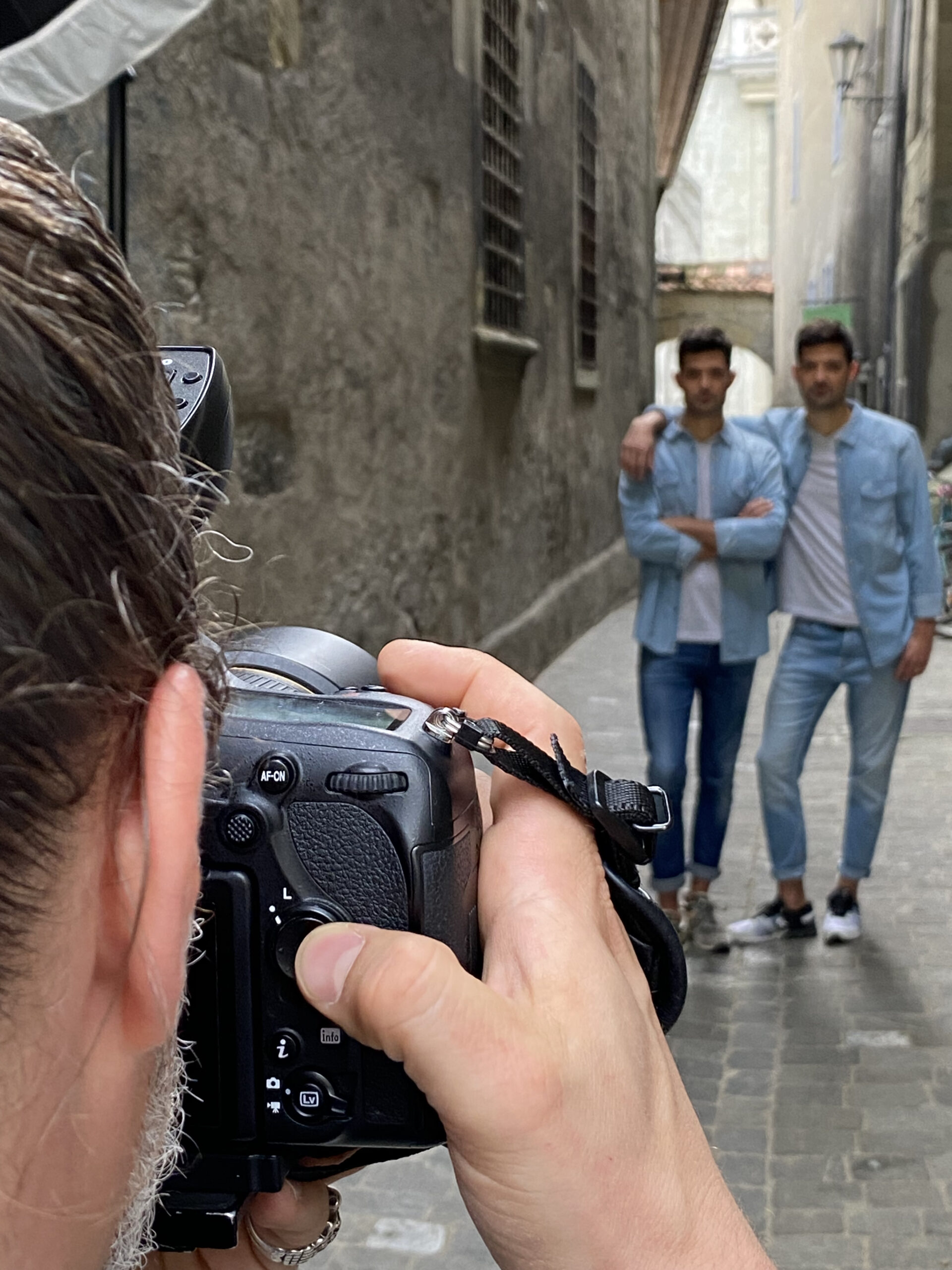 Zwillinge stehen in einer Nebengasse in Freiburg und werden Fotografiert.
