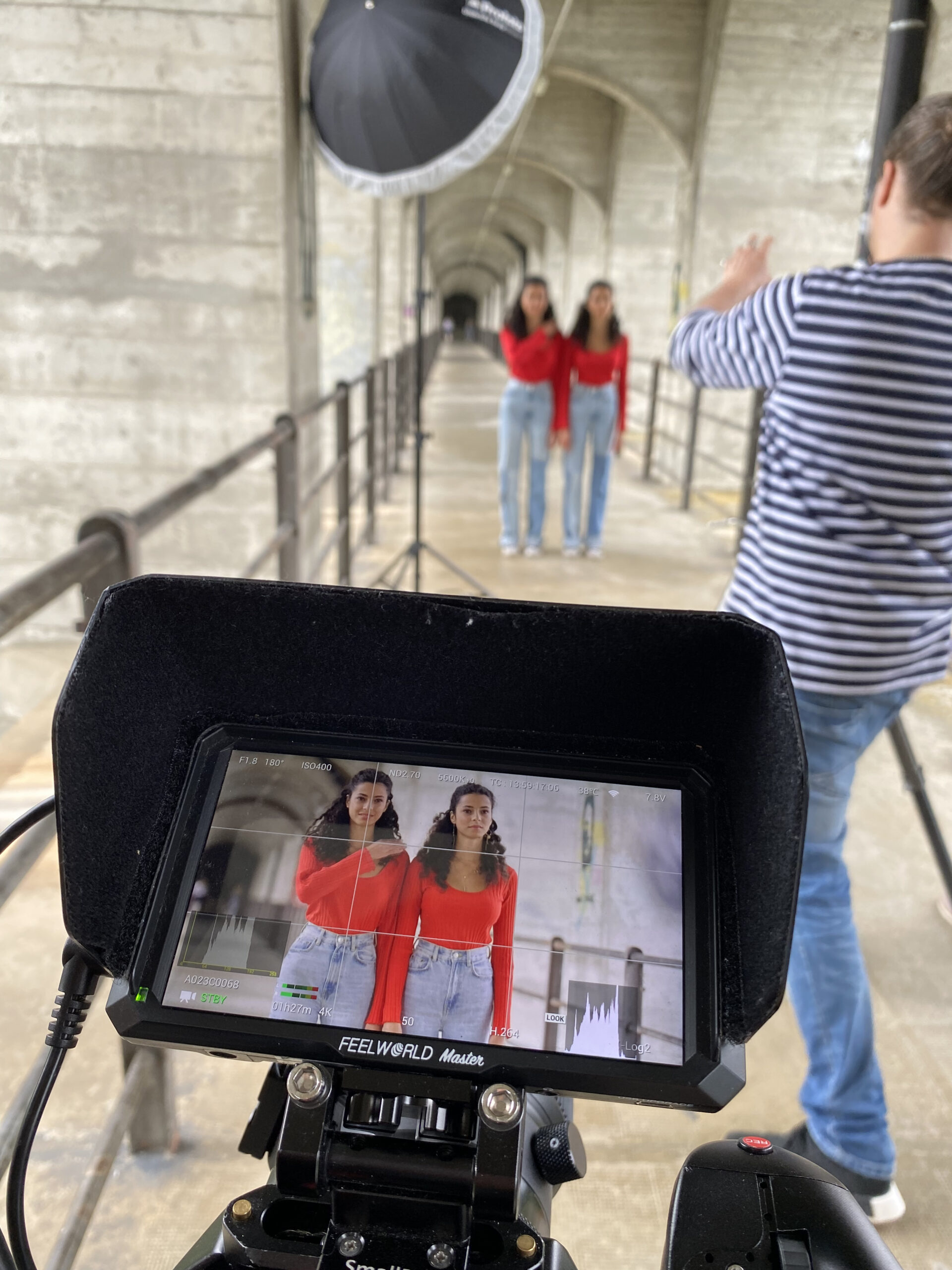 Grand Fey Br&uuml;cke in Freiburg mit Zwillingen und Fotograf. Zwei junge Frauen in roten Pullovern auf der Grand Fey Br&uuml;cke bei Fotoshoot. .