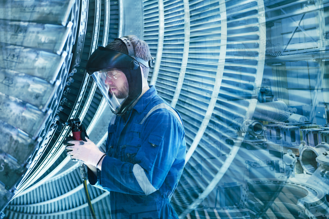 Mann bei Maschinenbau mit Spiegelungseffekt im Blauton. Mann mit Overall am Schweissen. KeyVisual der SAQ
