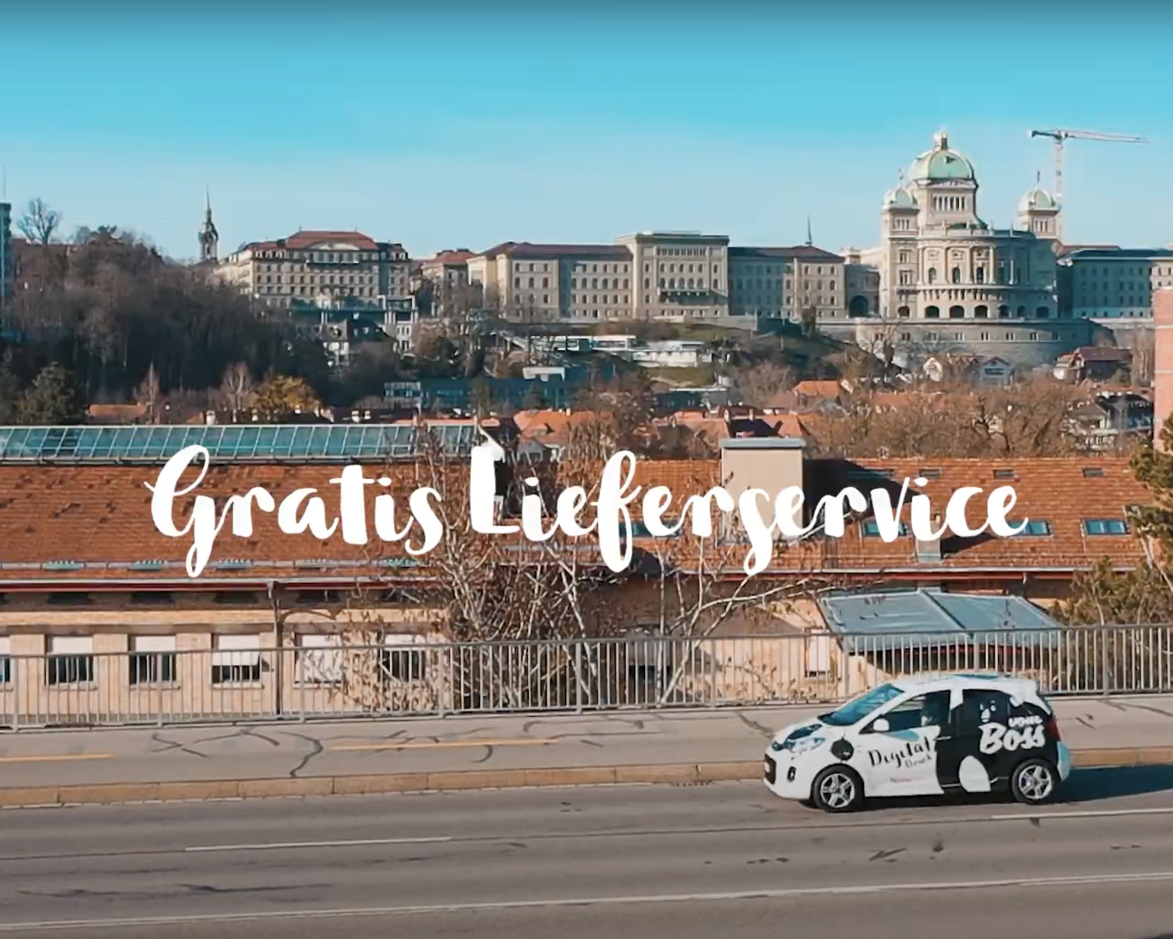 Boss Bern Firmenfahrzeug fährt über Kirchenfeld Brücke in Bern. Berner Bundeshaus im Hintergrund