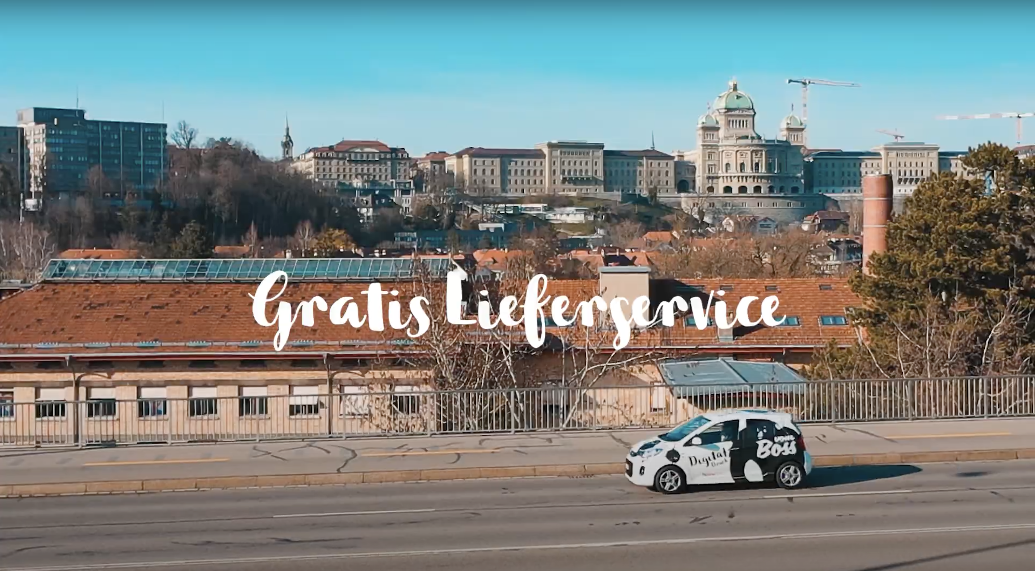 Boss Bern Firmenfahrzeug fährt über Kirchenfeld Brücke in Bern. Berner Bundeshaus im Hintergrund