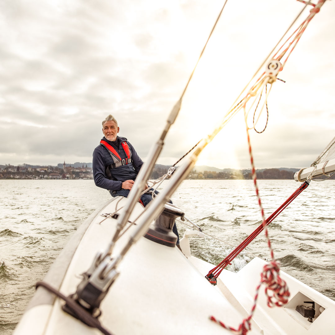 Mann auf Segelboot in stürmischer Umgebung auf dem Murtensee.