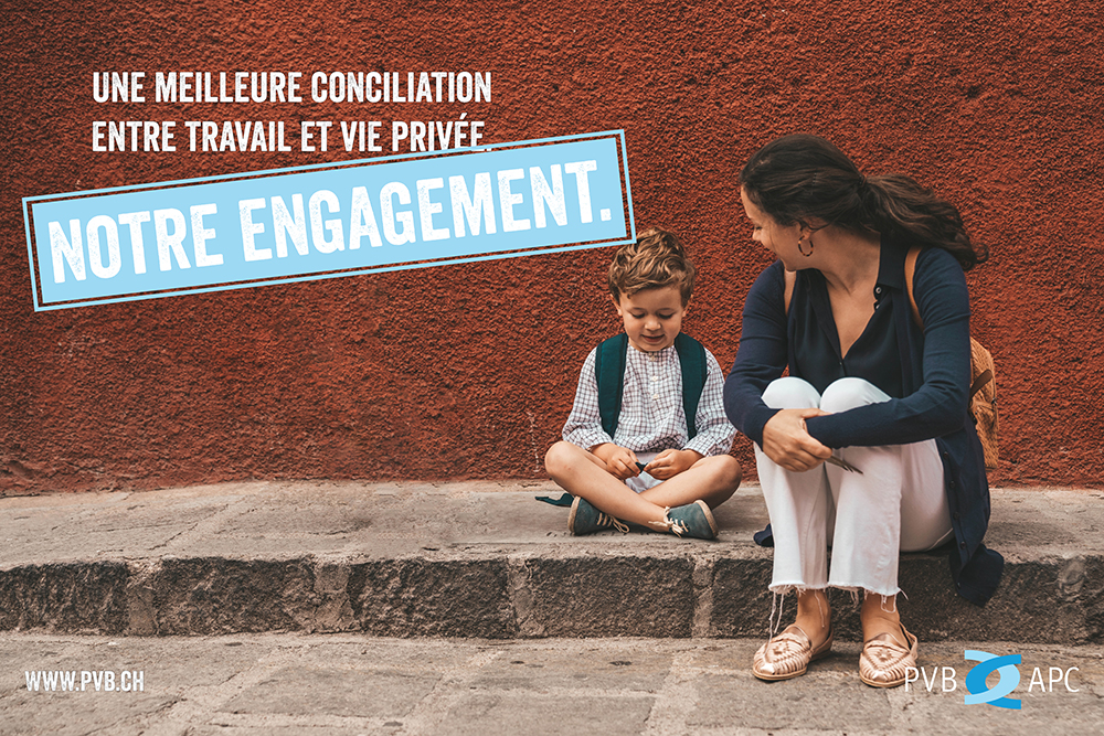 Mutter sitzt mit Kind vor einer Mauer auf dem Boden.