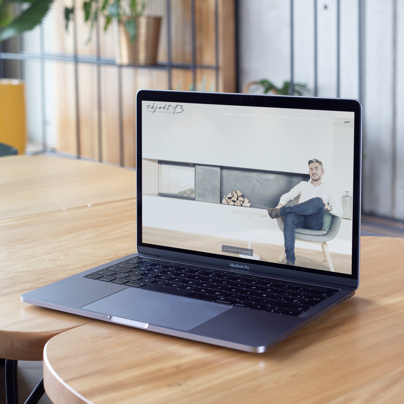 Webdesign und Konzeption f&uuml;r Innenarchitektur. MAC Book mit Mockup Objekt13 Webseite. MAC Book steht auf Couchtisch in ruhiger Atmosph&auml;re.