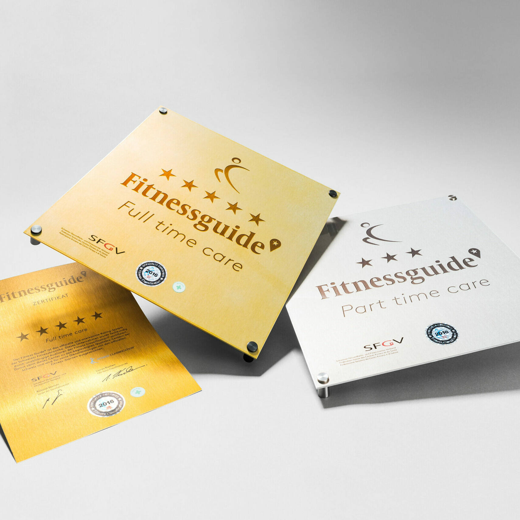 Gold und Silberplaketten Referenz Bilder liegend auf dem Tischf&uuml;r die Fitnessqualifikation - Fitness Classification Schweiz.